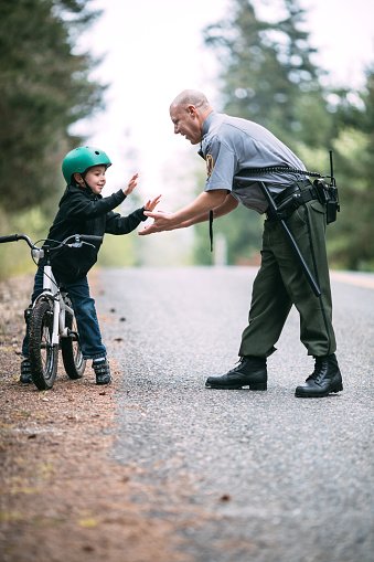 Police Officer Talking To Child On Bike Stock Photo ...